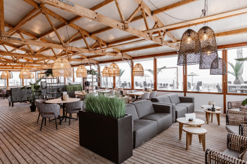 Stilfuldt indrettet loungeområde på Beach Houses Zandvoort 3 i Holland med havudsigt og træinteriør.