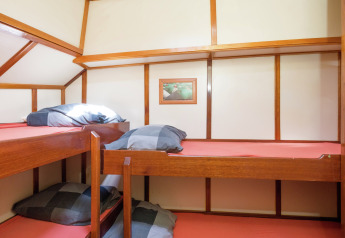 Habitación con dos literas de madera y sábanas rojas en una casa flotante de Leiden cerca del centro.