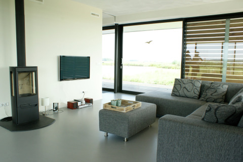 Moderne stue på husbåden Watervilla de Blauwe Reiger i Holland med sofa, pejs og store vinduer