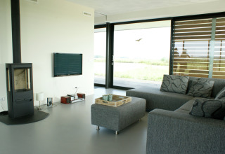Moderne stue på husbåden Watervilla de Blauwe Reiger i Holland med sofa, pejs og store vinduer