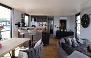 Modern interior of Houseboat 'Kohlenpott' in the Netherlands, featuring a kitchen, lounge, and water views.