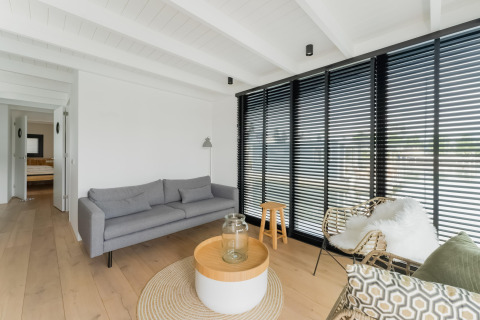 Lichte woonkamer op woonboot Boat House Stavoren met modern meubilair en grote ramen, Nederland.