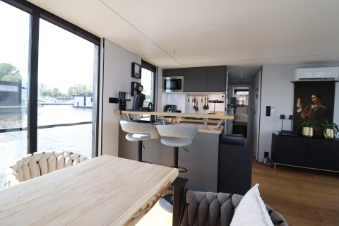 Modernes Wohnzimmer und Küche im Hausboot «Kohlenpott» in den Niederlanden mit Wasserblick.