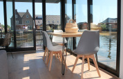 Helles Esszimmer auf Hausboot Boat House Stavoren mit großen Fenstern und Wasserblick in den Niederlanden.