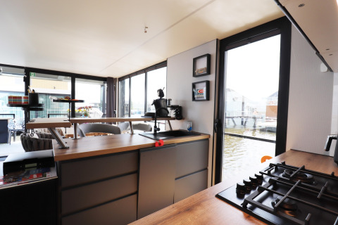 Moderne Küche auf dem Hausboot «Kohlenpott» in den Niederlanden mit Blick aufs Wasser durch große Fenster.