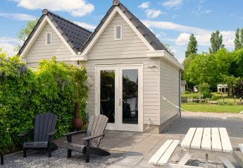 Außenbereich des Boat House Stavoren mit Sitzgelegenheiten, Tisch und grüner Umgebung in den Niederlanden.