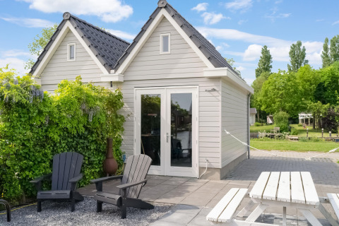 Buitenruimte bij Boat House Stavoren met zitjes, tafel en groen in Nederland op een zonnige dag.