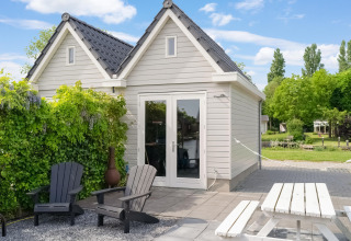 Buitenruimte bij Boat House Stavoren met zitjes, tafel en groen in Nederland op een zonnige dag.