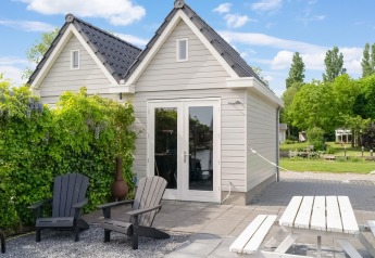 Außenbereich des Boat House Stavoren mit Sitzgelegenheiten, Tisch und grüner Umgebung in den Niederlanden.