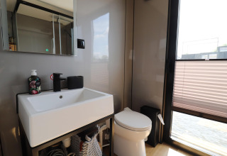 Modernes Badezimmer mit Waschbecken, Spiegel und Toilette auf dem Hausboot «Kohlenpott» in den Niederlanden.