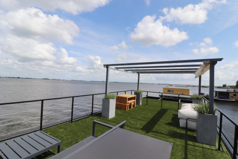 Dachterrasse des Hausboots «Kohlenpott» in den Niederlanden mit Kunstrasen, Sitzbereich und Seeblick.