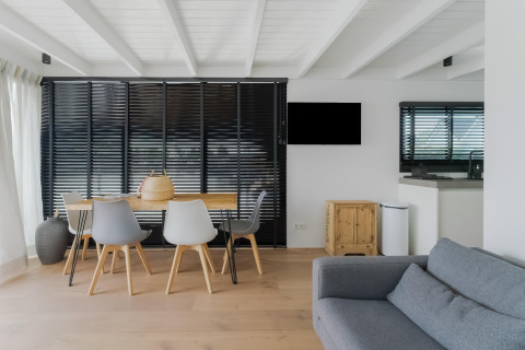 Moderne woon- en eetkamer van een woonboot bij Boat House Stavoren, Nederland, met strak interieur.