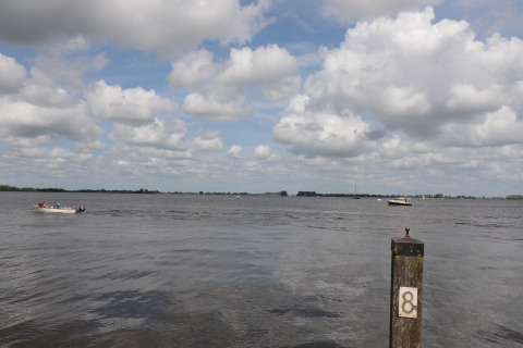 Uitzicht vanop woonboot 'Kohlenpott' in Nederland met boten op het water en een paal gemarkeerd met 8.
