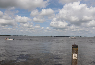 Uitzicht vanop woonboot 'Kohlenpott' in Nederland met boten op het water en een paal gemarkeerd met 8.