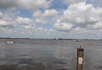 Vue depuis la péniche 'Kohlenpott' aux Pays-Bas, avec des bateaux sur l'eau et un poteau marqué 8.