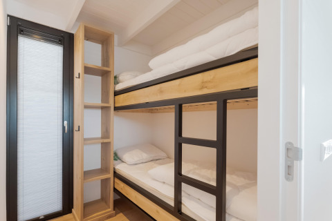 Moderne stapelbedden en open kast in een kamer van Boat House Stavoren, Nederland.