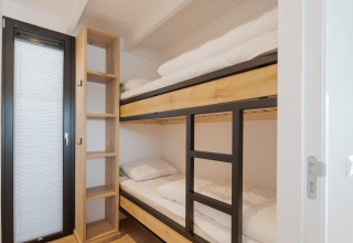 Moderne stapelbedden en open kast in een kamer van Boat House Stavoren, Nederland.