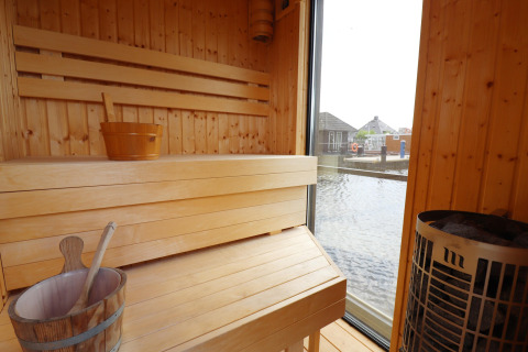 Binnenzicht van de sauna op woonboot 'Kohlenpott' in Nederland, met zicht op het water buiten.