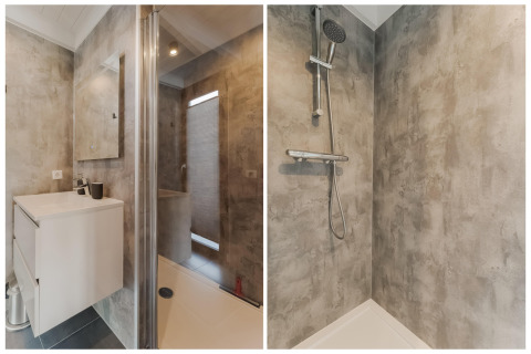 Moderne badkamer met douche en wastafel in betonlook op houseboat Boat House Stavoren in Nederland.