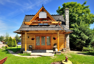 Sfeervol houten chalet genaamd 'A fabulous house in the mountains' in Tsjechië, omgeven door groen.