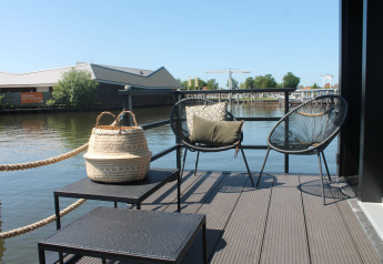 Terrasse eines Hausboots namens Boat House Stavoren in den Niederlanden mit Blick auf das Wasser.