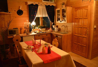 Knusse chaletkeuken met houten panelen, gedekte eettafel, kaarsen en landelijke sfeer in Tsjechië.