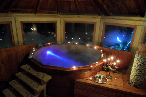 Romantisch chalet in Tsjechië met verlichte hot tub, kaarsen en sfeervol bergzicht 's avonds
