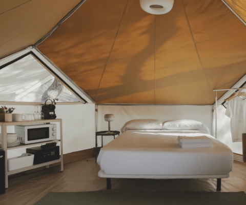 Innenansicht des Bell Tent im Wecamp Jávea, Spanien, mit gemütlichem Bett und Küchenzeile.