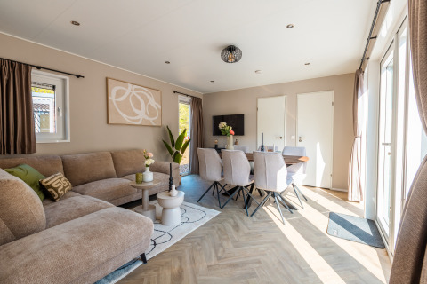 Bright, modern living and dining area at Groeneborg lodge met Hottub in Vakantiepark De Wiltzangh, Netherlands.
