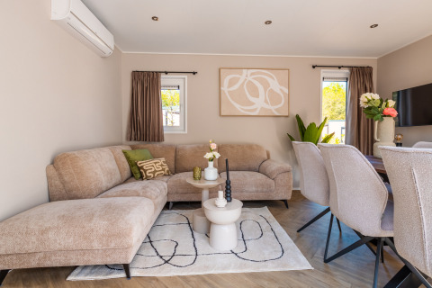 Soggiorno moderno a Groeneborg Lodge con divano accogliente, zona pranzo e arredamento elegante a De Wiltzangh.