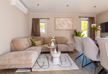 Moderne stue på Groeneborg Lodge med komfortabel sofa, spisestue og stilfuld dekoration i De Wiltzangh.