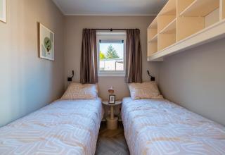 Zwei Einzelbetten in einem kleinen Zimmer der Groeneborg Lodge mit Hottub im Vakantiepark De Wiltzangh, Niederlande.
