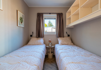 Zwei Einzelbetten in einem kleinen Zimmer der Groeneborg Lodge mit Hottub im Vakantiepark De Wiltzangh, Niederlande.