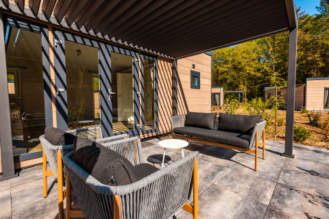Outdoor terrace with stylish seating at Groeneborg lodge met Hottub in Vakantiepark De Wiltzangh, Netherlands.