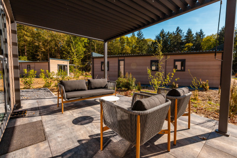 Moderne Terrasse mit Sitzgelegenheiten bei Groeneborg Lodge mit Hottub im Vakantiepark De Wiltzangh, Niederlande.