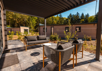 Zona de estar exterior en Groeneborg Lodge con bañera de hidromasaje en Vakantiepark De Wiltzangh, Países Bajos.