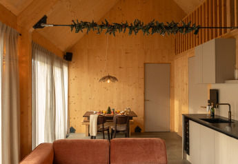 Modern houten lodge-interieur met eethoek en keuken bij Unbrick One Family op De Weelderik, Nederland.