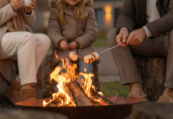 Family roasting marshmallows over a firepit at Unbrick One Family | Sauna and Pool, De Weelderik, Netherlands.