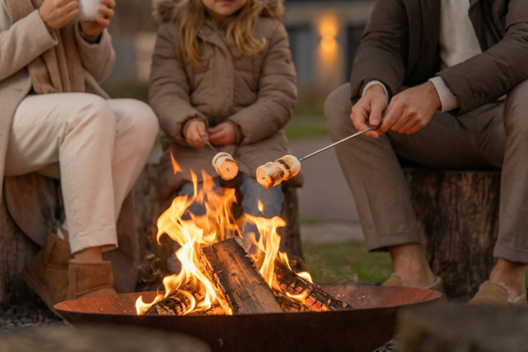 Familie röstet Marshmallows am Lagerfeuer vor Unbrick One Family | Sauna and Pool, De Weelderik, Niederlande.