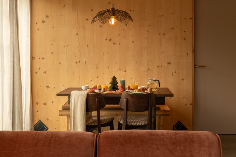 Cozy breakfast setup at Unbrick One | Sauna and Pool lodge, featuring wood walls and warm, inviting lighting.