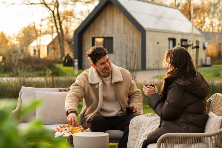 Ein Paar genießt Snacks und Getränke im Freien bei Unbrick One | Sauna and Pool in De Weelderik, Niederlande.