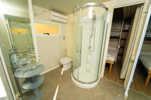 Badeværelse og soveområder i en Cottage Clever-lodge på Vallicella Glamping Resort i Italien.