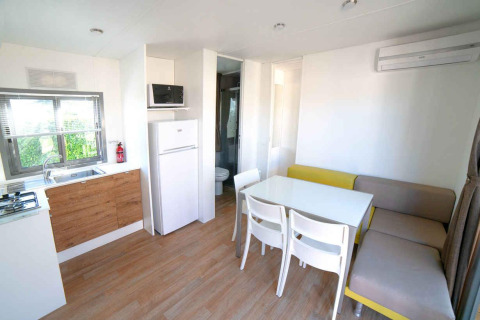 Moderne woon- en keukenruimte in een Next XL Superiore lodge bij Vacanze Glamping Boutique in Italië.