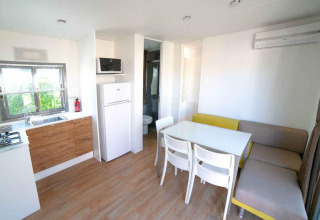 Moderne woon- en keukenruimte in een Next XL Superiore lodge bij Vacanze Glamping Boutique in Italië.