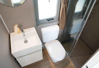 Moderne badkamer met wastafel, toilet en douche in de Next XL Superiore lodge bij Vacanze Glamping Boutique.