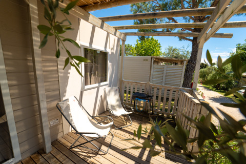Zonnig houten terras met twee loungestoelen en een barbecue bij de Next XL Superiore, Vacanze Glamping Boutique, Italië.