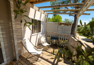 Zonnig houten terras met twee loungestoelen en een barbecue bij de Next XL Superiore, Vacanze Glamping Boutique, Italië.