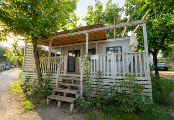 Udvendig udsigt til Cottage Next L 1/5 pers. lodgen med terrasse, træer og en hyggelig atmosfære.