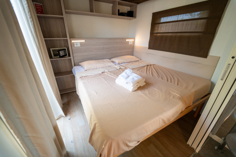 Dormitorio acogedor en Cottage Clever de Vacanze Glamping Boutique, Italia, con cama doble y toallas limpias.
