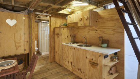 Houten interieur in Airlodge 2.0 bij Vacanze Glamping Boutique, Italië, met keuken en eethoek zichtbaar.